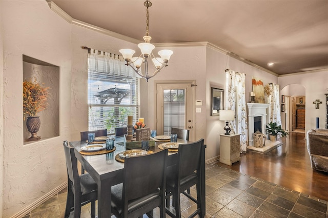 217 Silver Rose Blvd, Burleson, TX 76028 - dining room featuring a chandelier, stone tile floors, baseboards, ornamental molding, and arched walkways