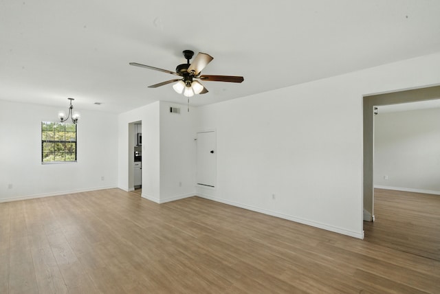 11720 Lavender Ave, Azle, TX 76020 - unfurnished room featuring a chandelier, ceiling fan, light wood-style flooring, and baseboards