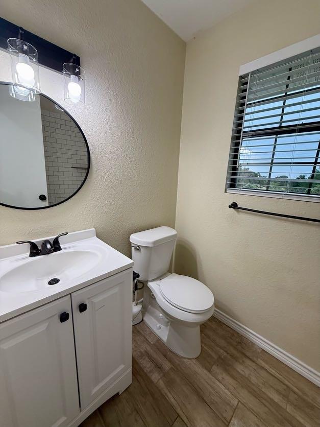 11720 Lavender Ave, Azle, TX 76020 - half bathroom with wood finished floors, a textured wall, and vanity