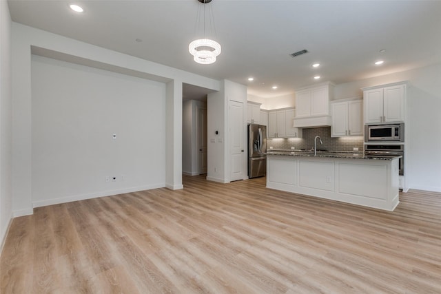 928 Marian Dr, Allen, TX 75013 - kitchen with appliances with stainless steel finishes, a sink, backsplash, light wood finished floors, and white cabinets