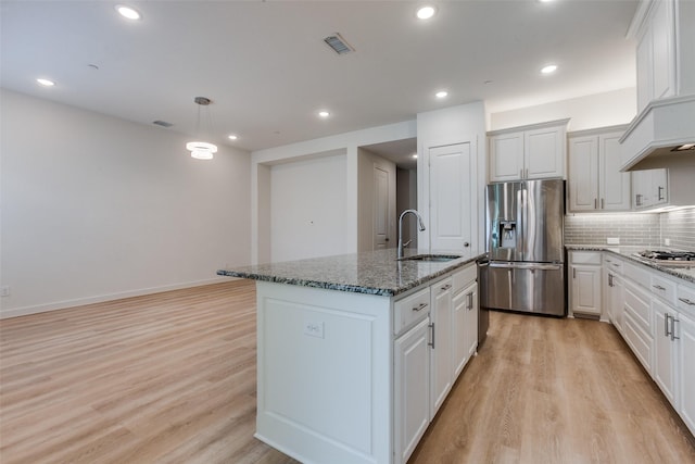 928 Marian Dr, Allen, TX 75013 - kitchen with appliances with stainless steel finishes, a sink, custom range hood, light wood-style flooring, and a center island with sink
