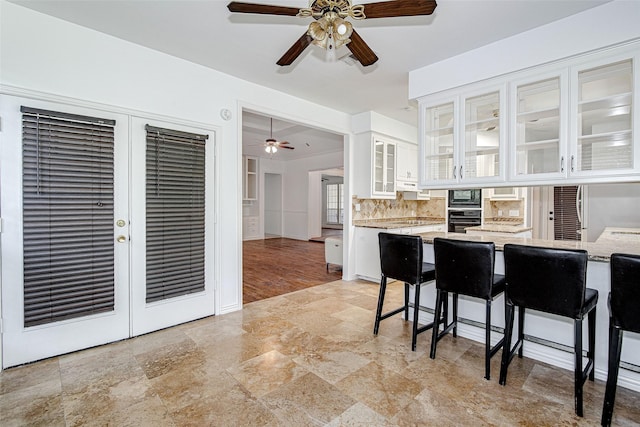 3308 Corn Valley Rd, Grand Prairie, TX 75052 - kitchen featuring black appliances, a ceiling fan, white cabinets, light stone finish floors, and tasteful backsplash