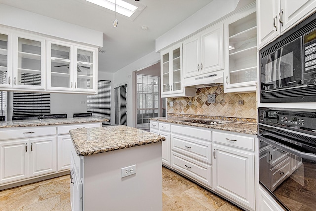3308 Corn Valley Rd, Grand Prairie, TX 75052 - kitchen with black appliances, a skylight, under cabinet range hood, backsplash, and glass insert cabinets