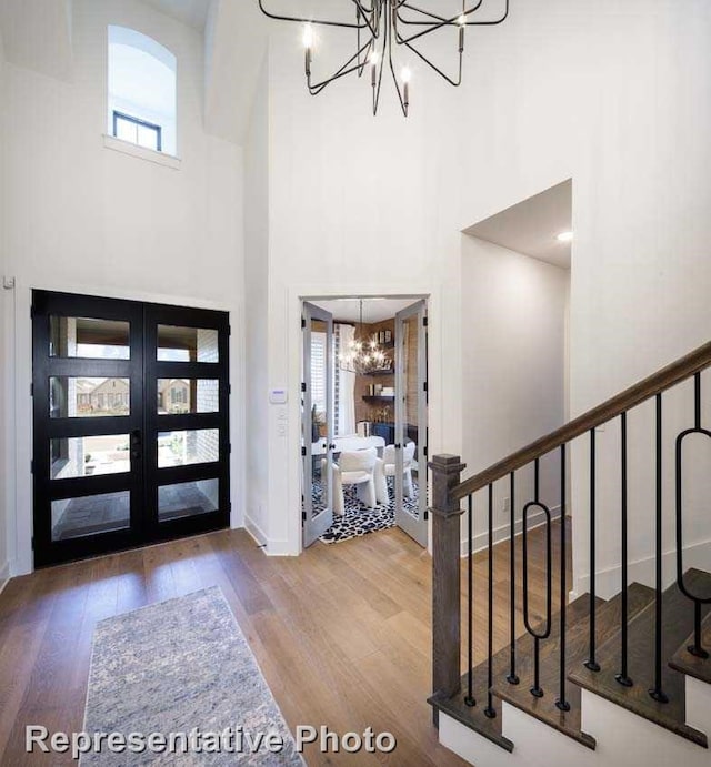 2761 Amber Ln, Prosper, TX 75078 - foyer entrance featuring a chandelier, a towering ceiling, wood finished floors, stairway, and baseboards