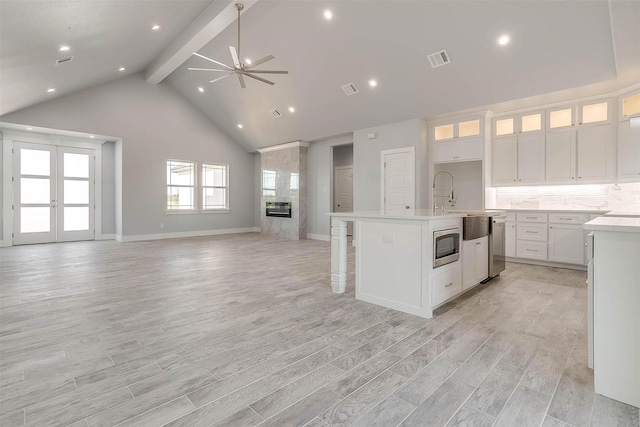580 Highview Ct, Godley, TX 76044 - kitchen featuring open floor plan, beam ceiling, a ceiling fan, white cabinetry, and light countertops