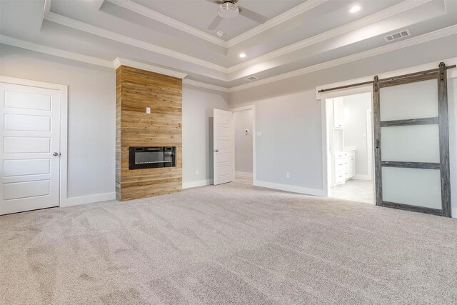 580 Highview Ct, Godley, TX 76044 - unfurnished living room featuring a tray ceiling, carpet flooring, a barn door, ceiling fan, and crown molding