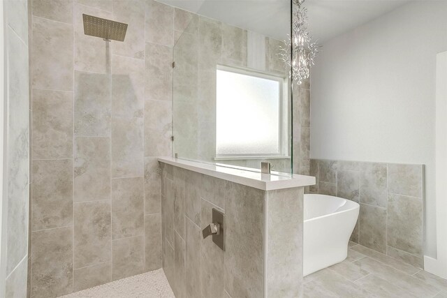 580 Highview Ct, Godley, TX 76044 - bathroom with a freestanding tub, a tile shower, and tile walls