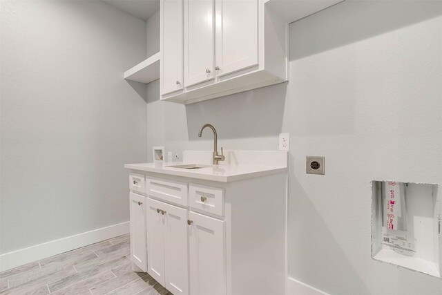 580 Highview Ct, Godley, TX 76044 - washroom with hookup for an electric dryer, hookup for a washing machine, baseboards, cabinet space, and light wood-style floors