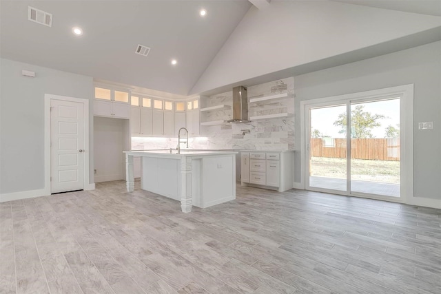 580 Highview Ct, Godley, TX 76044 - kitchen featuring open shelves, wall chimney exhaust hood, high vaulted ceiling, light countertops, and white cabinets