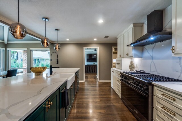 2021 Wing Point Ln, Plano, TX 75093 - kitchen featuring black range with gas cooktop, wall chimney exhaust hood, white cabinets, a sink, and decorative light fixtures