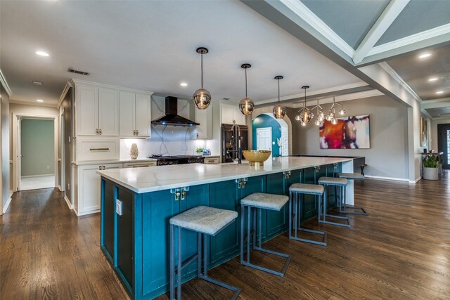 2021 Wing Point Ln, Plano, TX 75093 - kitchen with wall chimney exhaust hood, arched walkways, white cabinetry, crown molding, and a spacious island
