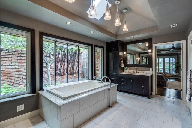 2021 Wing Point Ln, Plano, TX 75093 - ensuite bathroom with a garden tub, vanity, a raised ceiling, and baseboards