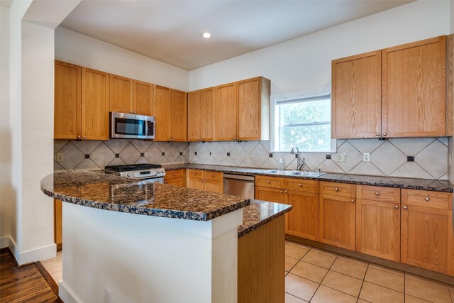4830 Cedar Springs Rd Unit 12, Dallas, TX 75219 - kitchen featuring appliances with stainless steel finishes, dark stone counters, backsplash, recessed lighting, and light tile patterned flooring