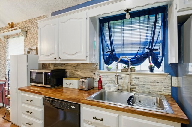 111 Christopher Dr, Cooper, TX 75432 - kitchen with butcher block countertops, black appliances, a sink, tasteful backsplash, and white cabinets