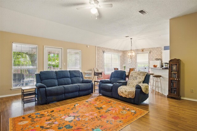 111 Christopher Dr, Cooper, TX 75432 - living area with ceiling fan, vaulted ceiling, a textured ceiling, baseboards, and wood finished floors