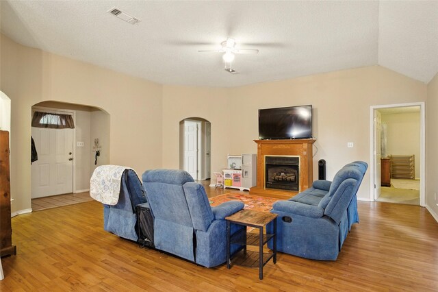111 Christopher Dr, Cooper, TX 75432 - living room with arched walkways, ceiling fan, light wood-type flooring, a fireplace with raised hearth, and baseboards