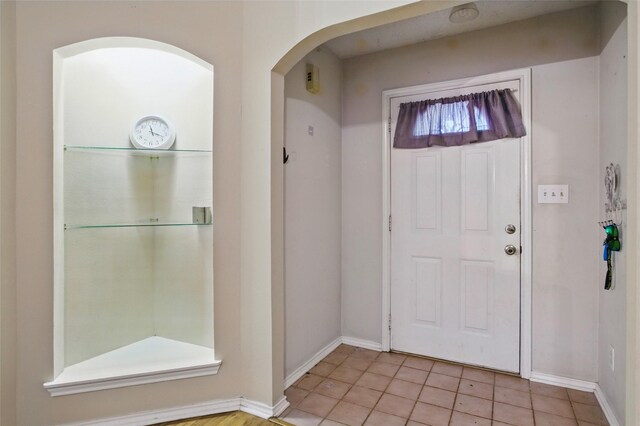 111 Christopher Dr, Cooper, TX 75432 - entryway featuring arched walkways, light tile patterned flooring, and baseboards