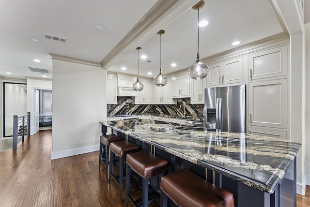 5055 Addison Cir Unit 723, Addison, TX 75001 - kitchen featuring stainless steel fridge with ice dispenser, decorative backsplash, crown molding, baseboards, and a breakfast bar area