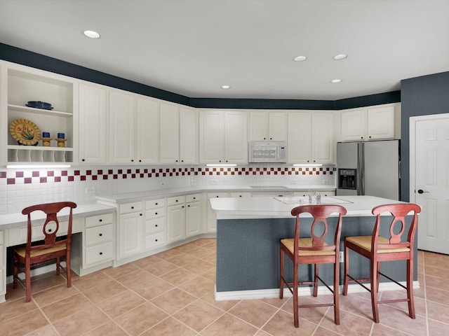 2832 Lincolnshire Dr, Richardson, TX 75082 - kitchen featuring white microwave, stainless steel fridge, light countertops, backsplash, and recessed lighting