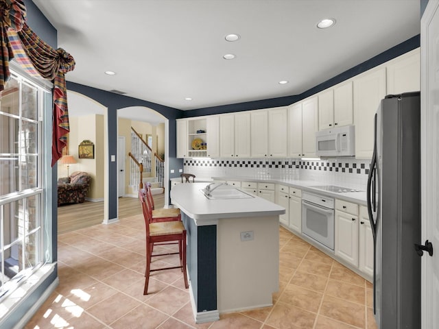2832 Lincolnshire Dr, Richardson, TX 75082 - kitchen featuring white appliances, arched walkways, backsplash, a sink, and recessed lighting