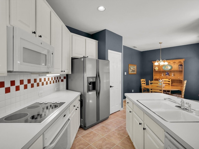 2832 Lincolnshire Dr, Richardson, TX 75082 - kitchen featuring white appliances, decorative backsplash, a sink, white cabinetry, and decorative light fixtures