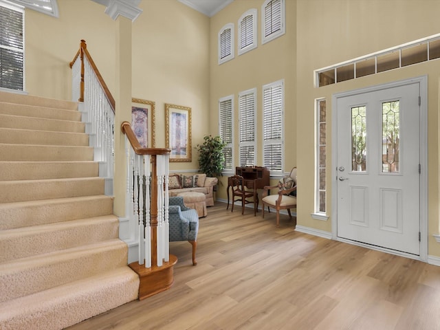 2832 Lincolnshire Dr, Richardson, TX 75082 - foyer entrance featuring wood finished floors, stairway, a high ceiling, baseboards, and crown molding