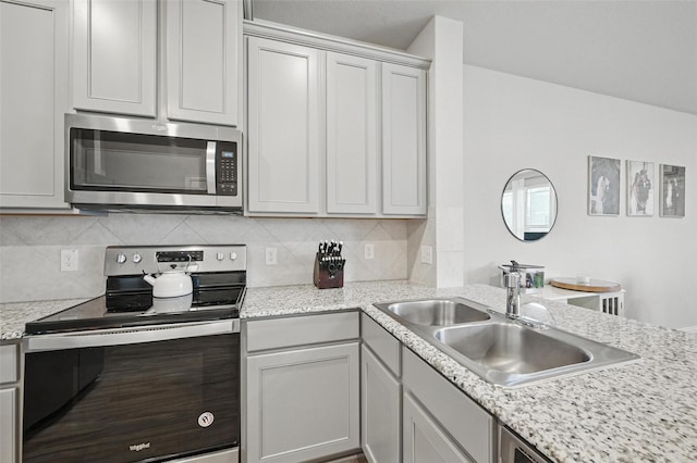 2409 Davenport Dr, Denton, TX 76207 - kitchen with appliances with stainless steel finishes, a sink, tasteful backsplash, and a peninsula