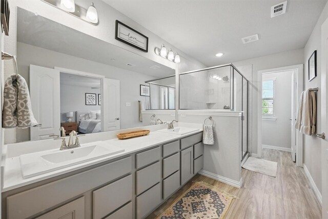 2409 Davenport Dr, Denton, TX 76207 - bathroom featuring ensuite bath, double vanity, wood finished floors, and a stall shower