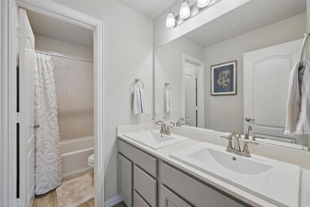 2409 Davenport Dr, Denton, TX 76207 - full bathroom with double vanity, toilet, shower / bathtub combination with curtain, and wood finished floors
