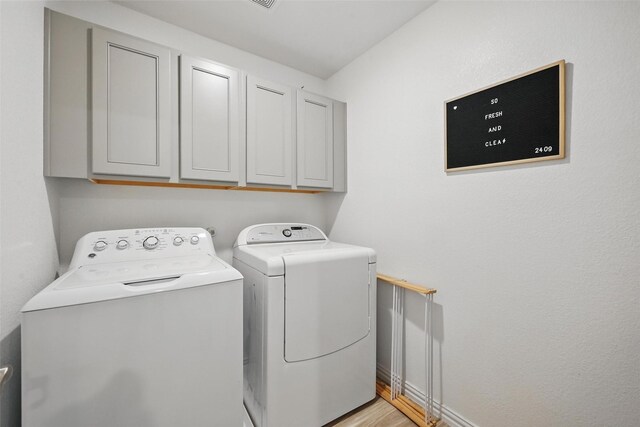 2409 Davenport Dr, Denton, TX 76207 - laundry area with washer and dryer, cabinet space, light wood-style floors, and baseboards