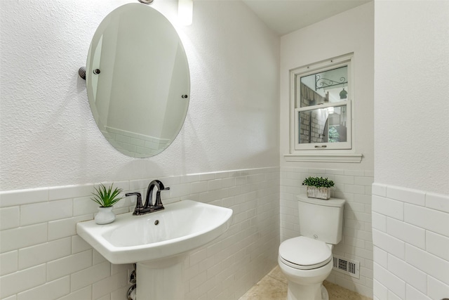 13841 Far Hills Ln, Dallas, TX 75240 - half bathroom with tile walls, wainscoting, and tile patterned floors