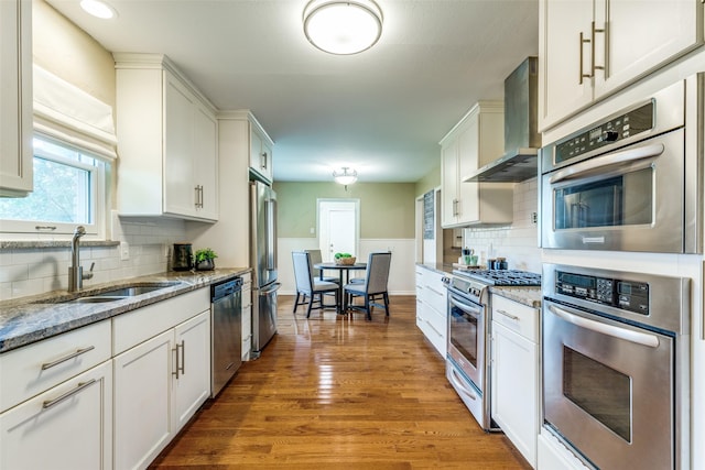 13841 Far Hills Ln, Dallas, TX 75240 - kitchen featuring wall chimney exhaust hood, stainless steel appliances, wood finished floors, white cabinets, and recessed lighting
