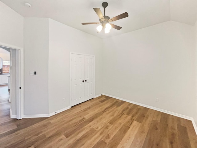 2140 Heather Glen Dr, Rockwall, TX 75087 - empty room featuring ceiling fan, light wood-style flooring, baseboards, vaulted ceiling, and a smoke detector