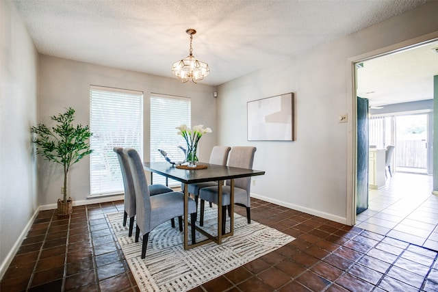 12332 Ferris Creek Ln, Dallas, TX 75243 - dining area featuring a chandelier, dark tile patterned floors, baseboards, and a textured ceiling