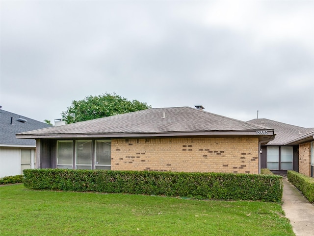 12332 Ferris Creek Ln, Dallas, TX 75243 - view of side of home featuring brick siding, a yard, and a shingled roof