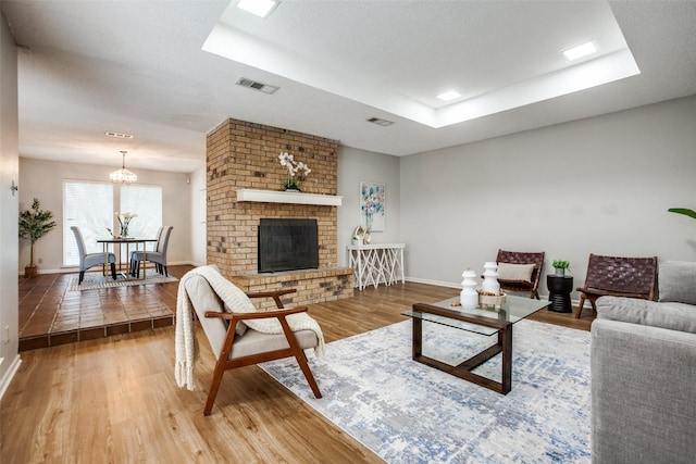 12332 Ferris Creek Ln, Dallas, TX 75243 - living room featuring a raised ceiling, wood finished floors, baseboards, and a chandelier
