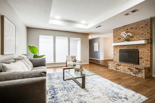 12332 Ferris Creek Ln, Dallas, TX 75243 - living room with a textured ceiling, wood finished floors, baseboards, and a fireplace