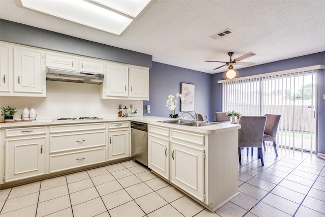 12332 Ferris Creek Ln, Dallas, TX 75243 - kitchen with stainless steel dishwasher, under cabinet range hood, a peninsula, light tile patterned floors, and a sink