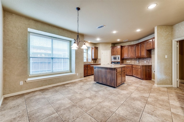 3500 Corkwood Dr, Frisco, TX 75033 - kitchen featuring stainless steel microwave, light tile patterned floors, light countertops, a kitchen island, and recessed lighting