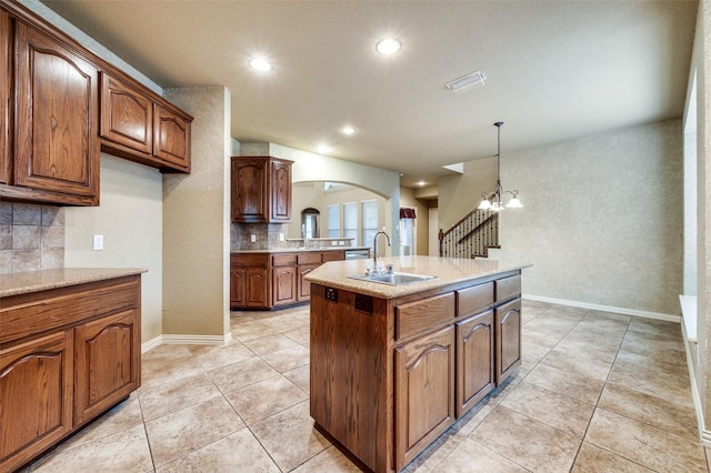3500 Corkwood Dr, Frisco, TX 75033 - kitchen with a sink, tasteful backsplash, arched walkways, light tile patterned floors, and decorative light fixtures