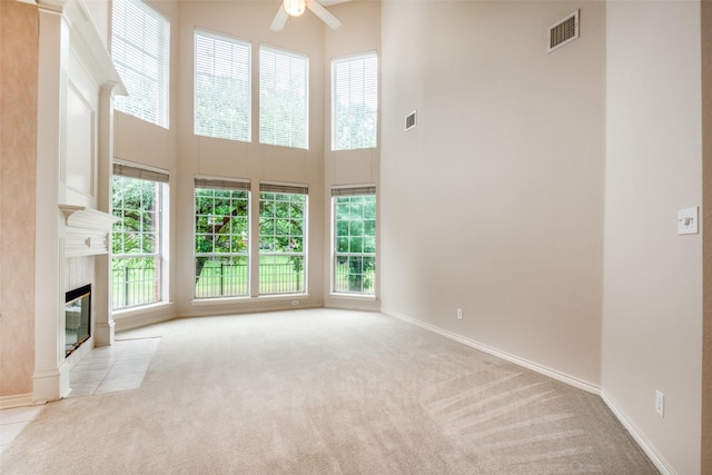8635 Forest Glen Dr, Irving, TX 75063 - unfurnished living room with a towering ceiling, healthy amount of natural light, a ceiling fan, and carpet