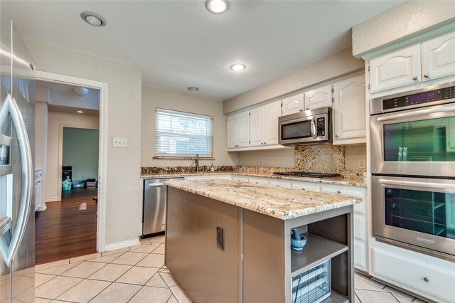 924 Mccoy Dr, Irving, TX 75062 - kitchen featuring stainless steel appliances, white cabinetry, light stone countertops, light tile patterned floors, and recessed lighting
