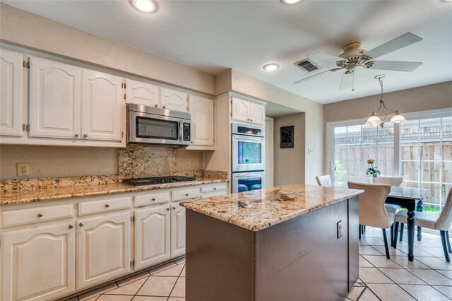 924 Mccoy Dr, Irving, TX 75062 - kitchen with stainless steel appliances, light tile patterned floors, ceiling fan, tasteful backsplash, and decorative light fixtures
