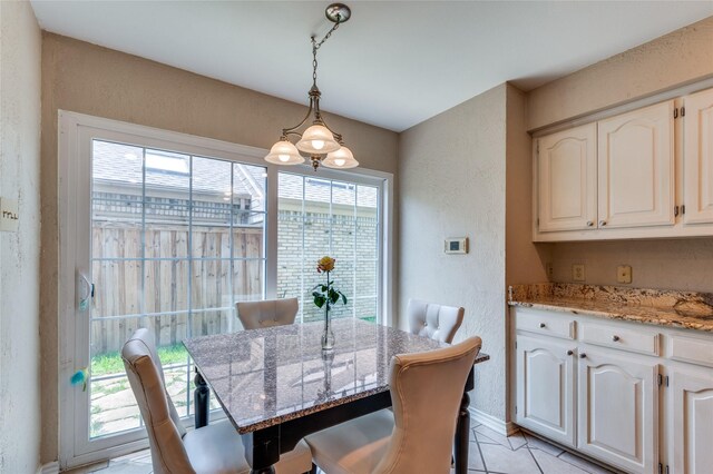 924 Mccoy Dr, Irving, TX 75062 - dining space featuring a textured wall, light tile patterned floors, and baseboards