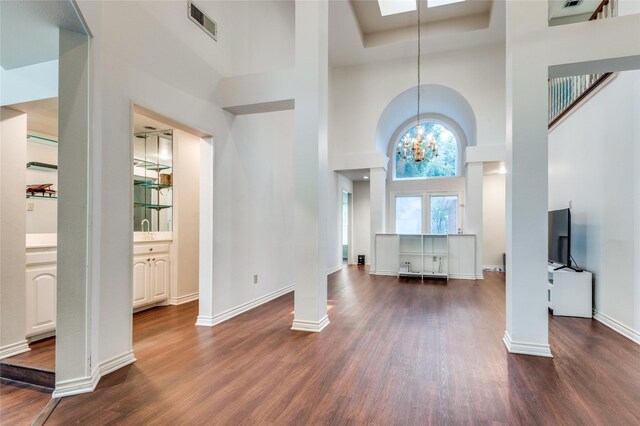 924 Mccoy Dr, Irving, TX 75062 - unfurnished living room with a high ceiling, dark wood-style flooring, a chandelier, and baseboards