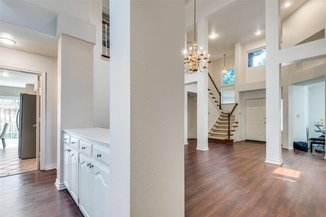 924 Mccoy Dr, Irving, TX 75062 - corridor with plenty of natural light, a chandelier, dark wood-style flooring, baseboards, and a towering ceiling