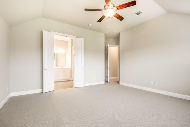 2409 Valley Ln, Carrollton, TX 75010 - unfurnished bedroom with vaulted ceiling, light colored carpet, baseboards, connected bathroom, and ceiling fan