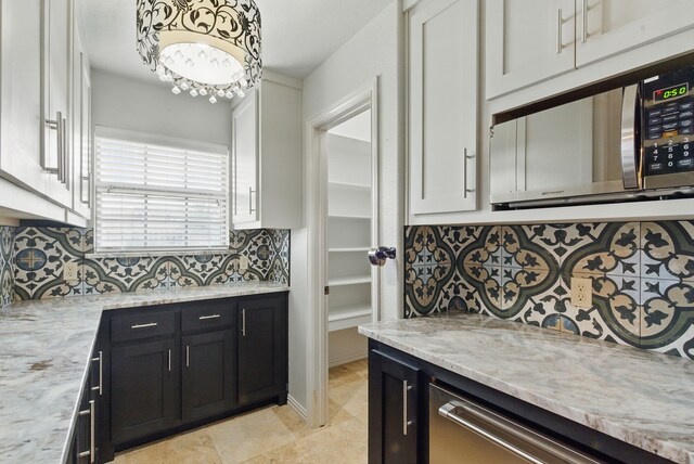 109 Pedernales Dr, New Fairview, TX 76078 - kitchen with appliances with stainless steel finishes, white cabinetry, backsplash, and light stone counters
