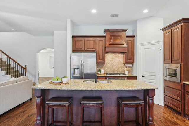 4324 Ashburn Way, Fort Worth, TX 76244 - kitchen with appliances with stainless steel finishes, a sink, custom range hood, arched walkways, and a kitchen bar