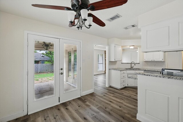 7616 Teresa Ct, North Richland Hills, TX 76182 - kitchen featuring a sink, ceiling fan, white cabinets, wood finished floors, and backsplash